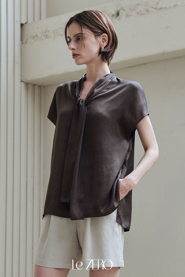 르제로 글로우 타이 블라우스는 플럼 브라운 컬러의 여성 블라우스입니다. 부드럽고 실키한 촉감의 폴리에스테르 소재로 제작되었으며, 은은한 광택과 약간의 신축성이 특징입니다. 타이넥 디자인과 넥라인 셔링 디테일, 넓은 숄더라인, 돌먼 소매, 시원한 착용감으로 우아하고 베이직한 스타일을 연출합니다.
