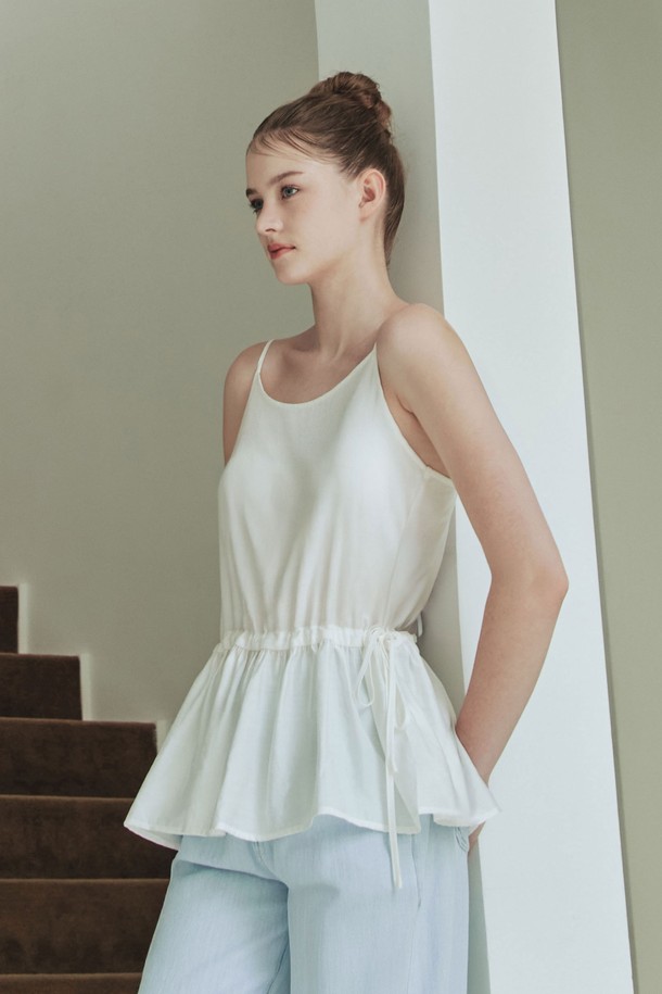 아이보리 컬러의 여성용 리본 셔링 슬리브리스입니다. 비스코스, 나일론, 텐셀 혼방 소재로 부드러운 촉감을 자랑하며, 봄, 여름에 시원하게 착용하기 좋습니다. 라운드넥, 루즈핏, 민소매 디자인으로 우아한 무드를 연출하며, 허리라인 플레어 디자인과 양옆의 리본 셔링 디테일이 특징입니다. 얇은 두께감과 앞면 긴 이너 라이닝으로 편안함과 스타일을 동시에 갖춘 데일리 상의입니다.
