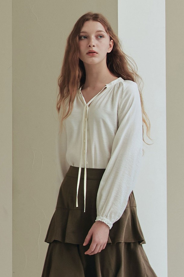 **엘리스 블라우스 / 아이보리**

부드러운 레이온과 나일론 혼방 소재의 엘리스 블라우스는 페미닌한 무드를 연출합니다. 릴랙스핏과 레귤러 기장으로 편안하게 착용 가능하며, 아이보리, 베이지 컬러의 스트라이프 패턴이 은은한 포인트를 더합니다. 브이넥 디자인과 네크라인 리본 디테일, 소매 커프스 개더링이 여성스러운 분위기를 강조하고, 앞중심 버튼과 바인딩 마감으로 깔끔하게 마무리되었습니다. 봄, 여름 데일리 및 데이트룩, 카페룩, 모임룩에 활용하기 좋은 블라우스입니다. 클래식, 미니멀, 로맨틱 스타일을 즐겨 입는 여성분들께 추천합니다.
