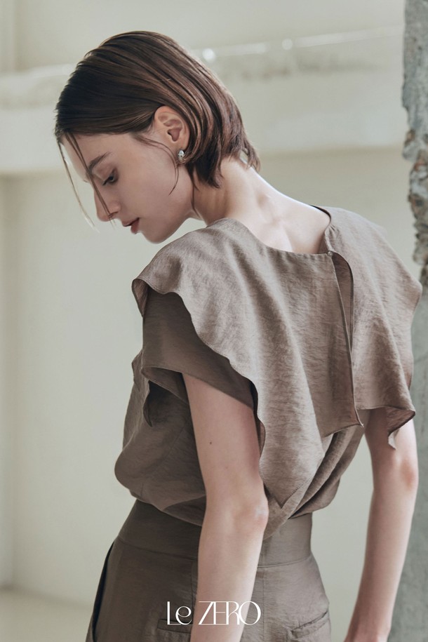 "르제로 플로웨어 프릴 블라우스 / 쿨 브라운"은 우아한 스타일을 연출하는 여성 블라우스입니다. 린넨 조직감과 시원한 터치감의 레이온, 나일론 혼방 소재로 제작되어 여름에도 쾌적하게 착용 가능하며, 루즈핏과 브이넥 디자인으로 편안함을 더했습니다. 긴 소매와 프릴 디테일이 여성스러운 분위기를 자아내며, 뒷 단추와 옆트임으로 포인트를 주었으며 비침 걱정 없이 부드럽고 매끄러운 촉감을 느낄 수 있습니다.
