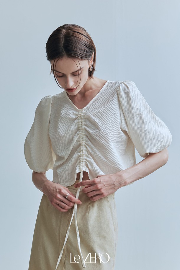 르제로 시어서커 스트링 블라우스 / 크림은 여름에 시원하게 즐길 수 있는 여성 블라우스입니다. 크림색상의 레귤러 핏으로, 폴리에스테르 소재의 시어서커 패턴이 특징이며, 브이넥 디자인에 반소매와 퍼프 소매, 밴딩 커프스로 페미닌한 무드를 더했습니다. 앞면 스트링으로 핏을 조절할 수 있어, 다양한 스타일 연출이 가능합니다.
