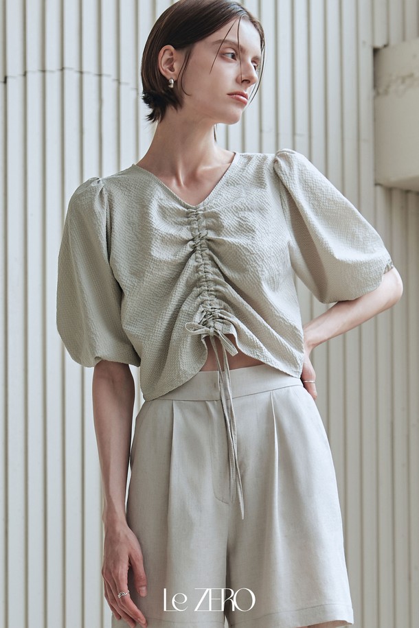 르제로 시어서커 스트링 블라우스는 카키 베이지 컬러의 여성 블라우스입니다. 봄, 여름 시즌에 어울리는 이 블라우스는 브이넥 디자인에 편안한 핏으로 우아한 스타일을 연출합니다. 볼륨감 있는 퍼프 소매와 소매 끝 밴딩 처리, 전면 스트링 디테일이 특징이며, 폴리에스테르 소재의 시어서커 패턴으로 제작되었습니다.
