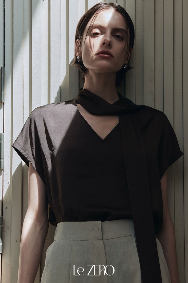 르제로 글로우 타이 블라우스는 플럼 브라운 컬러의 여성 블라우스입니다. 부드럽고 실키한 촉감의 폴리에스테르 소재로 제작되었으며, 은은한 광택과 약간의 신축성이 특징입니다. 타이넥 디자인과 넥라인 셔링 디테일, 넓은 숄더라인, 돌먼 소매, 시원한 착용감으로 우아하고 베이직한 스타일을 연출합니다.
