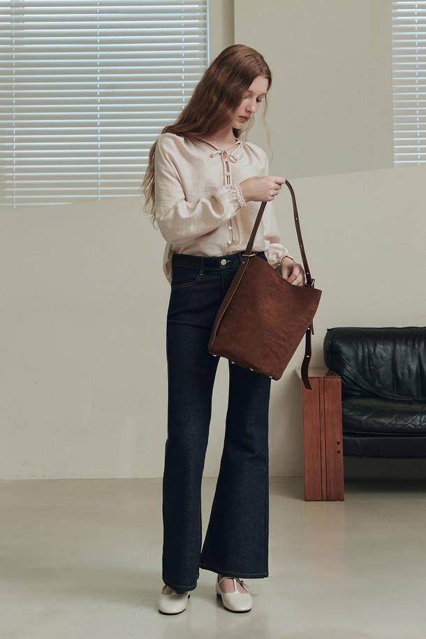 엘리스 블라우스 / 베이지는 여성스러운 무드를 연출하는 블라우스입니다. 부드러운 레이온과 나일론 혼방 소재로 제작되어 봄, 여름 시즌에 시원하게 착용할 수 있습니다. 은은한 광택과 세로 스트라이프 패턴이 우아한 분위기를 더하며, 브이넥 디자인과 루즈핏 실루엣으로 편안함을 선사합니다. 앞중심 버튼, 리본 스트랩, 소매단 셔링과 밴딩 디테일이 돋보이며, 오피스룩, 데이트룩, 모임룩 등 다양한 TPO에 활용 가능합니다. 클래식, 미니멀, 로맨틱 스타일을 즐겨 입는 분들께 추천합니다.
