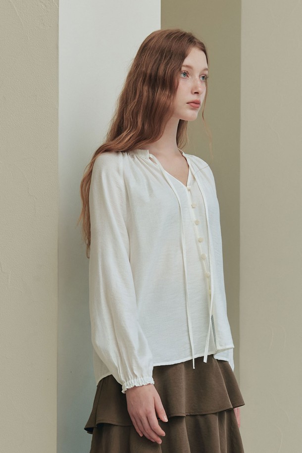 **엘리스 블라우스 / 아이보리**

부드러운 레이온과 나일론 혼방 소재의 엘리스 블라우스는 페미닌한 무드를 연출합니다. 릴랙스핏과 레귤러 기장으로 편안하게 착용 가능하며, 아이보리, 베이지 컬러의 스트라이프 패턴이 은은한 포인트를 더합니다. 브이넥 디자인과 네크라인 리본 디테일, 소매 커프스 개더링이 여성스러운 분위기를 강조하고, 앞중심 버튼과 바인딩 마감으로 깔끔하게 마무리되었습니다. 봄, 여름 데일리 및 데이트룩, 카페룩, 모임룩에 활용하기 좋은 블라우스입니다. 클래식, 미니멀, 로맨틱 스타일을 즐겨 입는 여성분들께 추천합니다.
