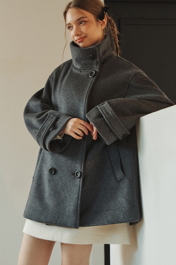 차분하고 세련된 무드의 울 더블 하프 코트입니다. 클래식과 미니멀 스타일을 모두 아우르는 디자인으로, 차콜 컬러가 시크한 분위기를 연출합니다. 부드러운 울과 폴리에스테르 혼방 소재로 제작되어 겨울철에도 따뜻하게 착용할 수 있으며, 하이넥 디자인과 소매단 스트랩, 미니멀 포켓 디테일이 돋보입니다. 루즈핏으로 편안한 착용감을 선사하며, 안감이 있어 더욱 쾌적하게 입을 수 있습니다. 출근룩, 오피스룩, 모임룩 등 다양한 TPO에 활용 가능합니다.

