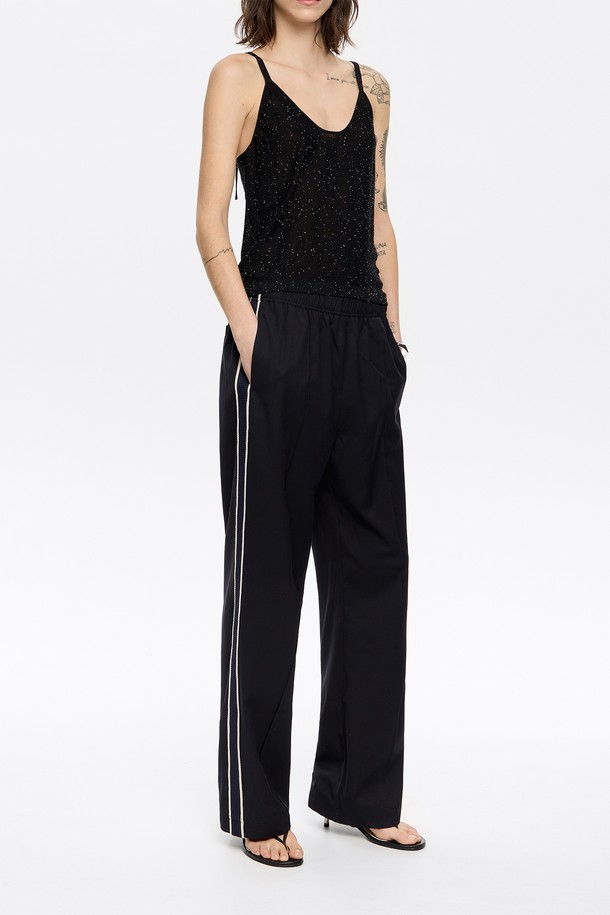 **[25SS] 빔바이롤라 사이드 테이프 조거 트라우저 B255AWP013BKB**

빔바이롤라(BIMBA Y LOLA)의 [25SS] 사이드 테이프 조거 트라우저입니다. 여성용 조거 팬츠로, 캐주얼하고 스포티한 스타일을 연출하기 좋습니다. 블랙 컬러에 릴랙스 핏으로 편안하게 착용 가능하며, 사이드 테이프 디테일이 돋보입니다. 봄, 여름에 어울리는 긴 기장의 바지로, 동네 마실룩, 여행룩, 피트니스룩 등 다양한 TPO에 활용할 수 있습니다. 폴리에스테르, 레이온, 스판덱스 혼방 소재로 제작되었으며, 밴딩 처리되어 편안한 착용감을 선사합니다. 더스트백이 함께 제공됩니다(블랙 또는 화이트 랜덤).
