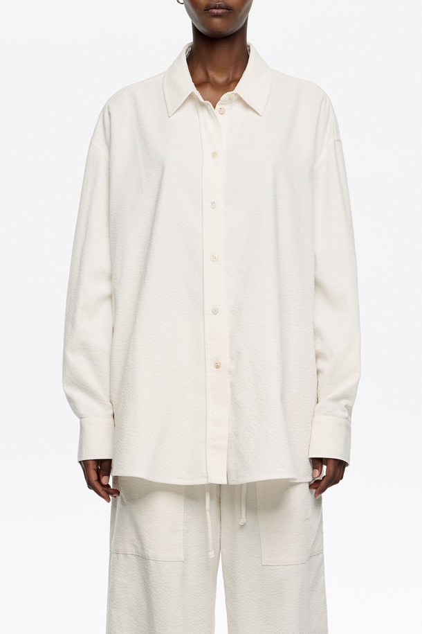 [25FW] 아이보리 텍스처 코튼 셔츠 B256AWB015IVB는 부드러운 컬러감과 미니멀한 디자인이 돋보이는 여성용 셔츠입니다. 가을, 겨울 시즌에 어울리는 두꺼운 두께감과 뻣뻣한 코튼 소재로 제작되어 포근하면서도 텍스처 디테일이 돋보입니다. 오버핏으로 편안한 착용감을 선사하며, 베이직한 스타일과 클래식한 무드를 동시에 연출할 수 있습니다. 칼라 넥 라인과 긴 소매 기장으로 세련된 분위기를 더하며, 출근룩으로도 활용하기 좋습니다.
