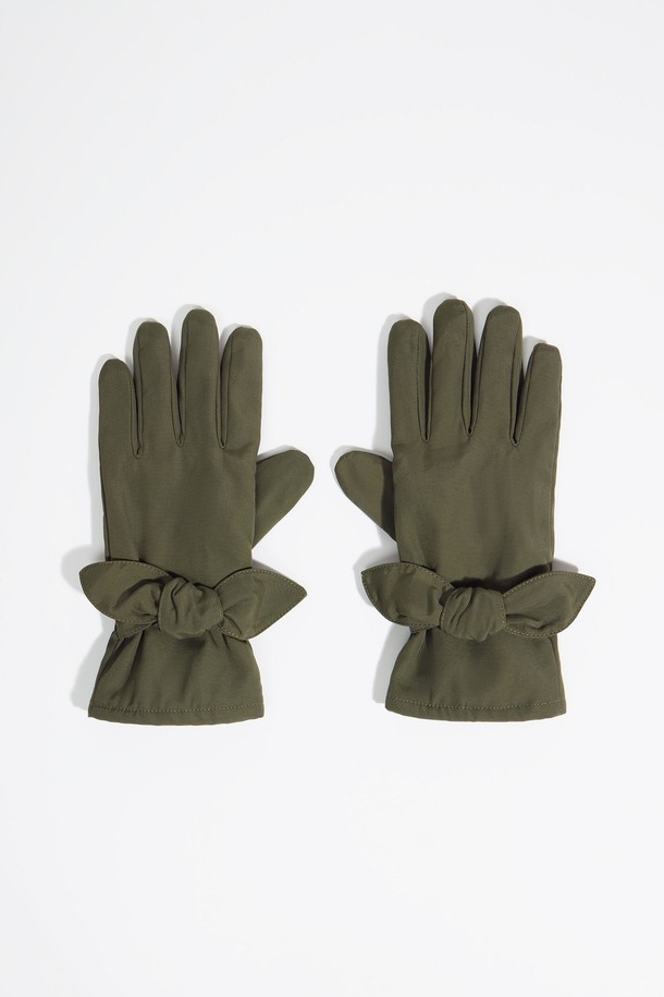 [25FW] 카키 나일론 장갑 B256AIG004KAB은 가을, 겨울철 일상과 출근 룩에 잘 어울리는 여성용 장갑입니다. 부드러운 촉감의 카키색 무지 디자인으로, 캐주얼, 클래식, 미니멀 스타일을 소화하기 좋습니다. 겉감은 폴리아미드 73%, 면 27%로 제작되었으며, 안감은 폴리에스터 69%, 폴리아미드 23%, 면 8%로 구성되어 보온성을 높였습니다. 손목 부분에 리본 장식이 있으며, 더스트백이 랜덤으로 포함될 수 있습니다. 
