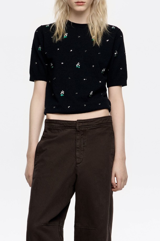 **[25FW] 블랙 라인스톤 반팔 스웨터 B256AWK011BKB**

세련된 블랙 컬러의 여성용 반팔 스웨터입니다. 가을과 겨울에 어울리는 포근한 니트 소재로 제작되었으며, 라운드넥과 레귤러핏 디자인으로 편안한 착용감을 선사합니다. 무지 패턴에 라인스톤과 비즈 장식이 더해져 캐주얼하면서도 화려한 포인트를 줍니다. 데이트룩, 모임룩 등 특별한 날을 위한 스타일링에 적합하며, 미니멀한 스타일을 즐기는 분들께 추천합니다. 숏 기장으로 트렌디함을 더했습니다.
