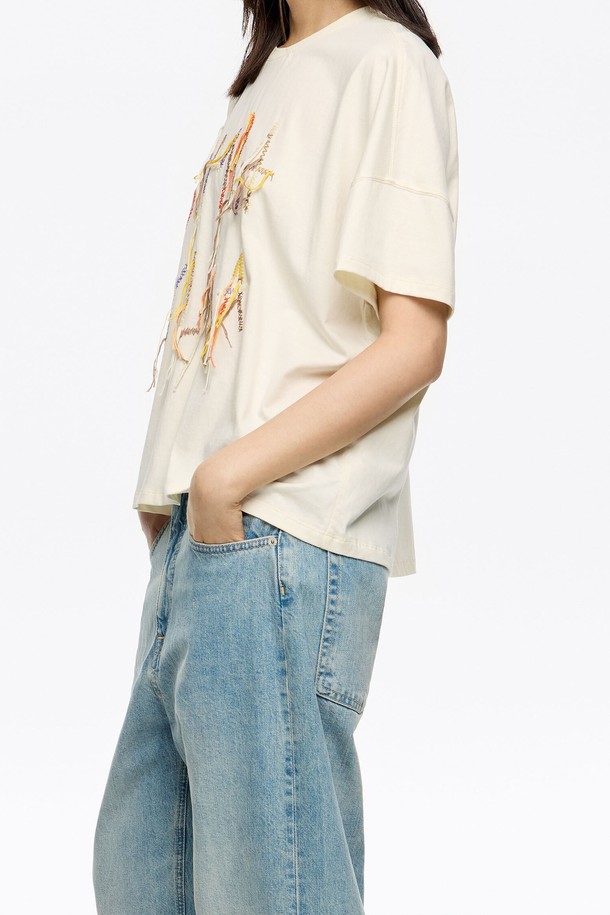 **[25FW] 아이보리 오버사이즈 엠브로더리 행잉 로고 티셔츠**는 여성용 티셔츠로, 가을과 겨울에 어울리는 캐주얼 스타일의 아이템입니다. 아이보리 색상의 면과 폴리에스터 혼방 소재로 제작되었으며, 라운드넥에 반소매 기장으로 편안하게 착용할 수 있습니다. 오버핏 실루엣에 엠브로더리 로고 패턴이 특징이며, 레귤러 기장으로 디자인되었습니다. 겨울 데일리룩에 활용하기 좋으며, 더스트백이 함께 제공됩니다 (블랙 또는 화이트 중 랜덤).
