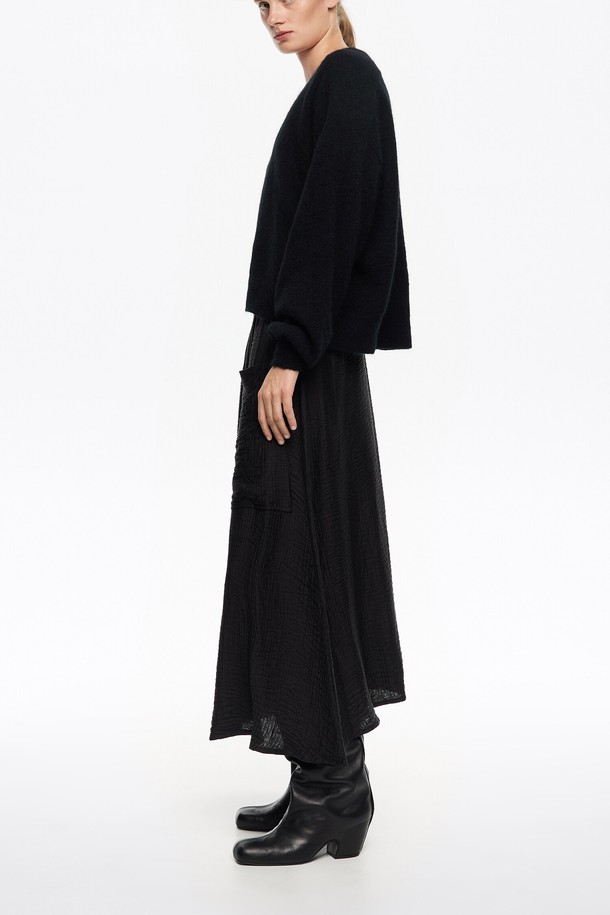 [25FW] 워시드 블랙 드저스터블 플루이드 스커트 B256AWS008BKA는 여성용 스커트입니다. 미니멀하고 베이직한 스타일로, 가을과 겨울에 착용하기 좋습니다. 워시드 가공된 블랙 컬러의 플레어 타입 플루이드 스커트로, 루즈핏 디자인이 특징입니다. 
