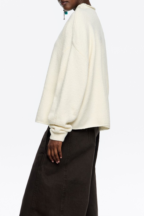 [25FW] 빔바이롤라 아이보리 코튼 박시 스웨터 B256AWK019IVB는 여성용 니트/스웨터입니다. 가을, 겨울 시즌에 어울리는 두꺼운 두께감의 긴소매 스웨터로, 부드러운 촉감이 특징입니다. 아이보리 색상의 무지 디자인에 모크넥 라인과 루즈핏으로 편안한 착용감을 선사합니다. 면, 나일론, 아크릴, 스판덱스 혼방 소재로 제작되어 캐주얼, 미니멀, 클래식 스타일 연출에 용이합니다. 일상복으로 활용하기 좋은 베이직한 디자인의 스웨터입니다.
