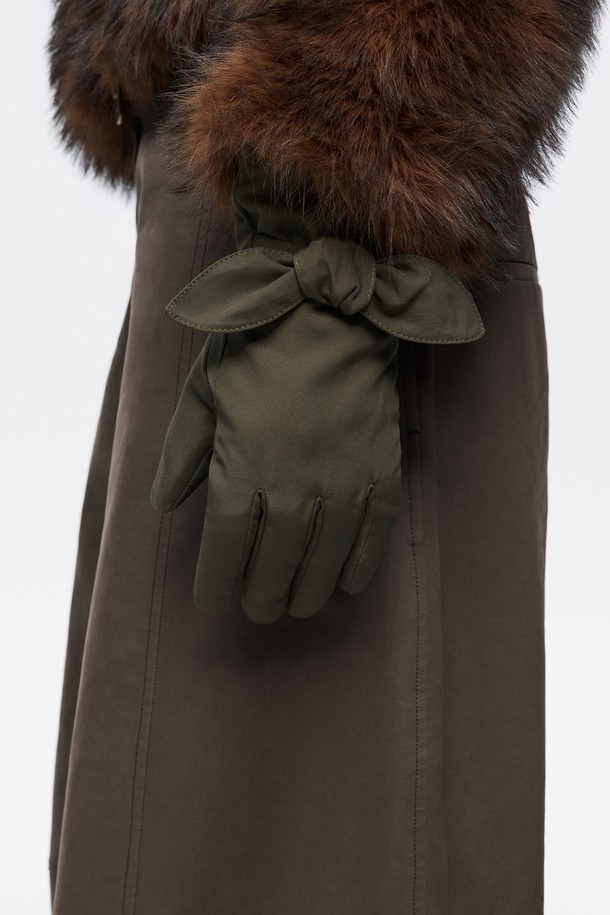 [25FW] 카키 나일론 장갑 B256AIG004KAB은 가을, 겨울철 일상과 출근 룩에 잘 어울리는 여성용 장갑입니다. 부드러운 촉감의 카키색 무지 디자인으로, 캐주얼, 클래식, 미니멀 스타일을 소화하기 좋습니다. 겉감은 폴리아미드 73%, 면 27%로 제작되었으며, 안감은 폴리에스터 69%, 폴리아미드 23%, 면 8%로 구성되어 보온성을 높였습니다. 손목 부분에 리본 장식이 있으며, 더스트백이 랜덤으로 포함될 수 있습니다. 
