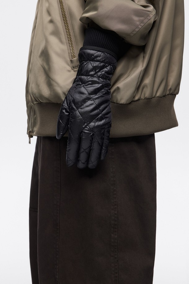 [25FW] 블랙 나일론 패딩 장갑 B256AIG005BKB는 겨울철 추위를 막아주는 여성용 패딩 장갑입니다. 부드러운 촉감의 나일론, 폴리아미드, 폴리에스테르 소재를 사용하여 보온성을 높였으며, 다이아몬드 퀼팅 디자인이 특징입니다. 캐주얼, 미니멀, 클래식 스타일에 잘 어울리며, 출근룩에도 활용하기 좋습니다. 두꺼운 두께감으로 뛰어난 보온성을 제공하며, 시보리(리브) 커프스로 마감하여 찬 바람을 효과적으로 차단합니다. 블랙 색상의 무지 디자인으로 어떤 스타일에도 쉽게 매치할 수 있습니다.
