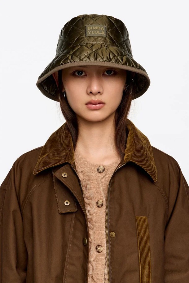 **[25FW] 카키 나일론 버킷햇 B256AIH010KAB**

가을, 겨울 시즌에 어울리는 여성용 카키색 나일론 버킷햇입니다. 부드러운 촉감과 두꺼운 두께감으로 따뜻하게 착용할 수 있습니다. 무지 디자인에 퀄팅, 패치, 로고 장식이 더해져 캐주얼, 미니멀, 클래식 스타일 모두 소화 가능합니다. 일상에서 편안하게 착용하기 좋은 아이템입니다.
