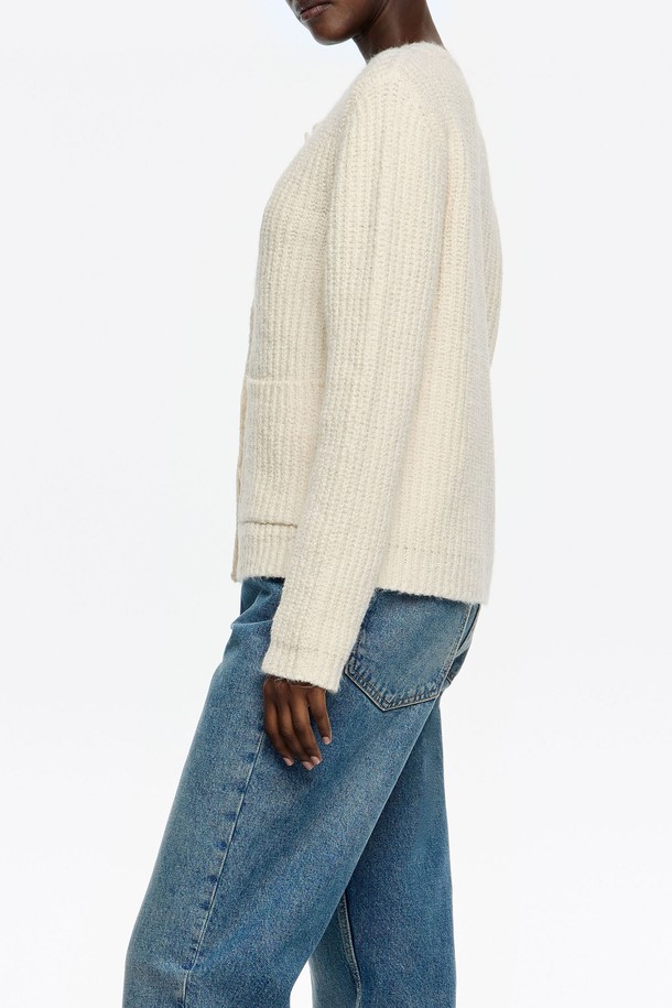 **[25FW] 아이보리 피티드 카디건 B256AWG010IVB**는 여성 의류 상의 카테고리에 속하는 니트/스웨터입니다. 아이보리 컬러의 슬림핏 카디건으로, 봄, 가을, 겨울 계절에 착용하기 좋습니다. 라운드넥 디자인에 긴소매, 골지 무늬가 특징이며, 캐주얼 및 베이직 스타일을 연출하기 좋습니다. 출근룩과 모임룩, 그리고 미니멀한 스타일을 선호하는 분들께 추천합니다. 면, 폴리에스테르, 아크릴 혼방 소재로 제작되었습니다.
