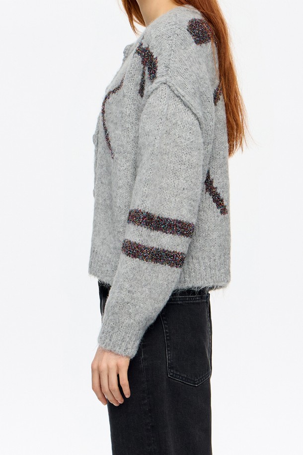 [25FW] 라이트 그레이 틴셀 벌룬 가디건 B256AWG001GRB는 여성용 가을/겨울 상의입니다. 라이트 그레이 컬러의 무지 디자인으로, 캐주얼, 미니멀, 클래식 스타일을 연출할 수 있습니다. 숏 기장의 라운드 넥 가디건으로, 루즈핏과 벌룬 핏이 특징이며, 긴소매 디자인입니다. 아크릴, 폴리에스테르, 나일론 혼방 소재로 제작되어 부드러운 촉감과 두꺼운 두께감을 제공합니다.
