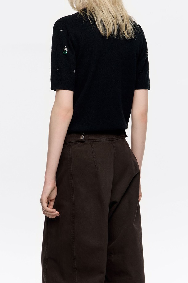 **[25FW] 블랙 라인스톤 반팔 스웨터 B256AWK011BKB**

세련된 블랙 컬러의 여성용 반팔 스웨터입니다. 가을과 겨울에 어울리는 포근한 니트 소재로 제작되었으며, 라운드넥과 레귤러핏 디자인으로 편안한 착용감을 선사합니다. 무지 패턴에 라인스톤과 비즈 장식이 더해져 캐주얼하면서도 화려한 포인트를 줍니다. 데이트룩, 모임룩 등 특별한 날을 위한 스타일링에 적합하며, 미니멀한 스타일을 즐기는 분들께 추천합니다. 숏 기장으로 트렌디함을 더했습니다.
