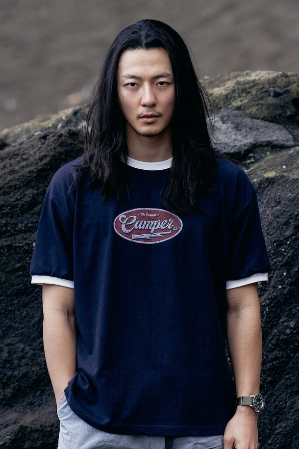 네이비 컬러의 크랙 써클 링거 티셔츠는 캠퍼 레터링과 번개 그래픽 로고 프린트가 돋보이는 남성 반소매 티셔츠입니다. 얇은 면 소재로 제작되어 봄, 여름철 일상복으로 적합하며, 링거 티셔츠 디자인과 배색 포인트 디테일이 캐주얼하고 스포티한 스타일을 연출합니다. 레귤러 핏의 라운드넥 디자인으로 편안하게 착용할 수 있습니다.
