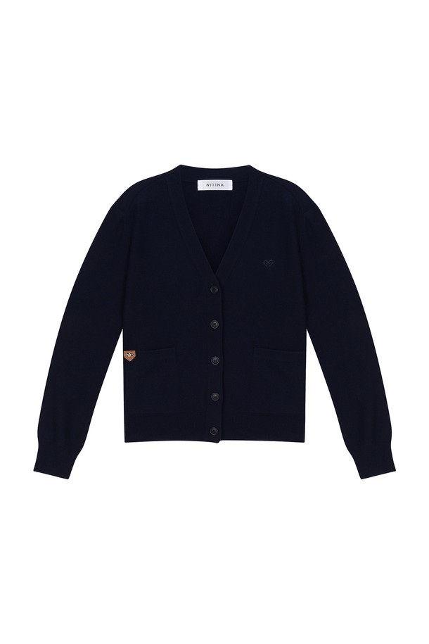 **캐시미어 브이넥 가디건 D/NY**는 여성 의류로, 세련되고 심플한 스타일을 연출합니다. 다크네이비, 오렌지, 골프그린, 다크그레이 4가지 색상으로 출시되었으며, 봄, 가을, 겨울에 착용하기 좋습니다. 부드러운 캐시미어, 울, 레이온, 나일론 혼방 소재로 제작되어 편안한 착용감을 선사합니다. NITINA 시그니처 자수와 에지 리브 마감 디테일이 돋보이며, 자연스러운 핏의 긴소매 브이넥 디자인입니다. 오피스룩과 모임룩은 물론, 클래식, 미니멀, 캐주얼 스타일에도 잘 어울립니다.

