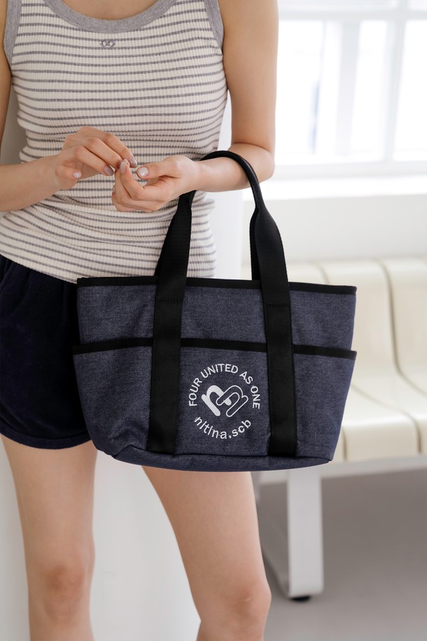 데님 더블 토트백 BL은 면과 폴리에스테르 혼방 소재의 여성 토트백입니다. 블루와 블랙 두 가지 컬러로 출시되었으며, 미디엄 사이즈로 넉넉한 수납 공간을 제공합니다. 가방 전면에 NITINA 2N 하트 시그니처 자수 장식이 돋보이며, 탈부착 스트랩과 내부 포켓이 있어 실용적입니다. 숄더백 겸용으로, 짧은 핸들과 스냅 잠금 방식으로 편안하게 사용할 수 있으며, 캐주얼 및 클래식 스타일을 연출하여 골프룩과 일상룩 모두에 활용 가능합니다.
