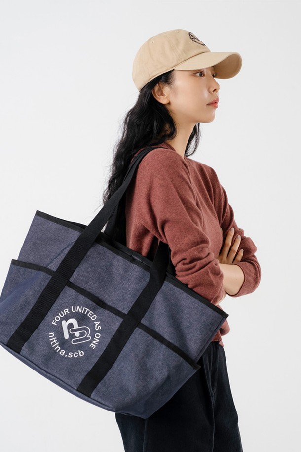 **데님 숄더 백 BL**

블루와 블랙 컬러로 만나볼 수 있는 데님 숄더 백입니다. 넉넉한 라지 사이즈로, 면과 폴리에스테르 혼방 소재로 제작되어 튼튼합니다. 가방 전면에 자수 로고 장식이 돋보이며, 내부에는 7개의 포켓이 있어 수납력을 높였습니다. 스냅 잠금 방식으로 편리하며, 긴 손잡이로 어깨에 편안하게 멜 수 있습니다. 캐주얼, 클래식, 미니멀한 스타일을 즐기는 분들께 데일리, 여행, 골프룩에 활용하기 좋은 아이템입니다.
