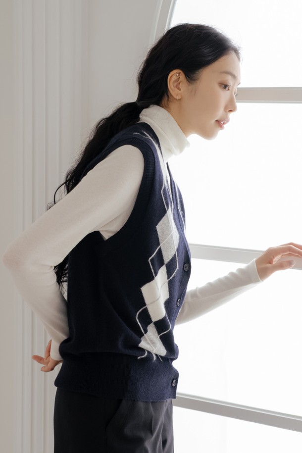 캐시미어 블렌딩 아가일 베스트 D/NY는 여성 골프룩을 위한 클래식하고 미니멀한 스타일의 베스트입니다. 블랙과 화이트 두 가지 색상으로 출시되었으며, 부드러운 촉감의 캐시미어 혼방 소재로 제작되어 가을, 겨울 시즌에 따뜻하게 착용할 수 있습니다. 브이넥 라인에 레귤러핏으로 디자인되었으며, 아가일 패턴과 니트 소재, 버튼 여밈 디테일이 특징입니다. 민소매 디자인으로 활동성을 높였으며, 두꺼운 두께감으로 보온성을 더했습니다.
