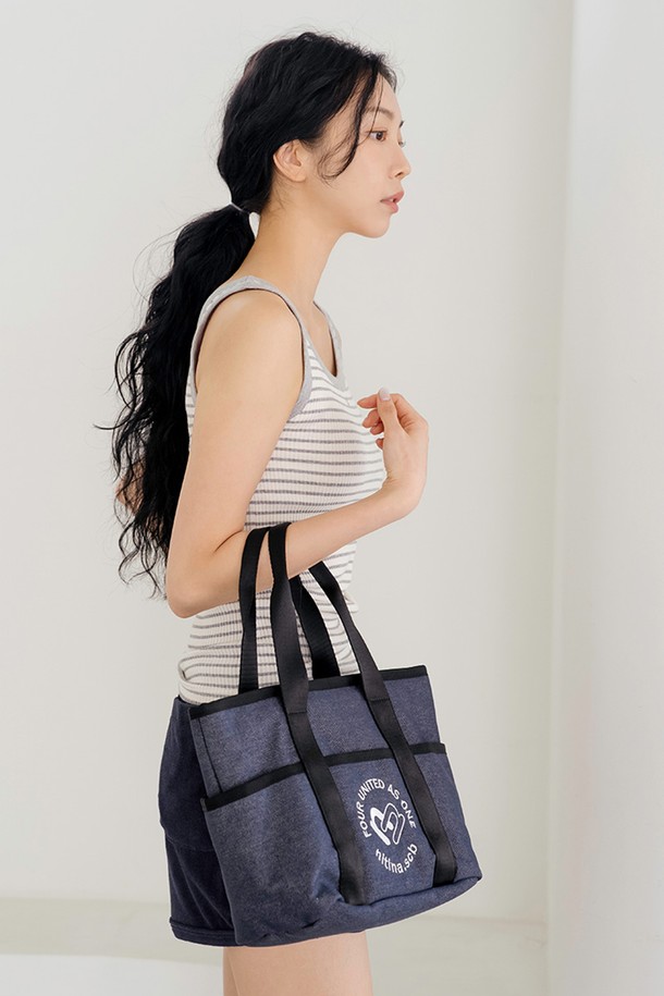데님 더블 토트백 BL은 면과 폴리에스테르 혼방 소재의 여성 토트백입니다. 블루와 블랙 두 가지 컬러로 출시되었으며, 미디엄 사이즈로 넉넉한 수납 공간을 제공합니다. 가방 전면에 NITINA 2N 하트 시그니처 자수 장식이 돋보이며, 탈부착 스트랩과 내부 포켓이 있어 실용적입니다. 숄더백 겸용으로, 짧은 핸들과 스냅 잠금 방식으로 편안하게 사용할 수 있으며, 캐주얼 및 클래식 스타일을 연출하여 골프룩과 일상룩 모두에 활용 가능합니다.
