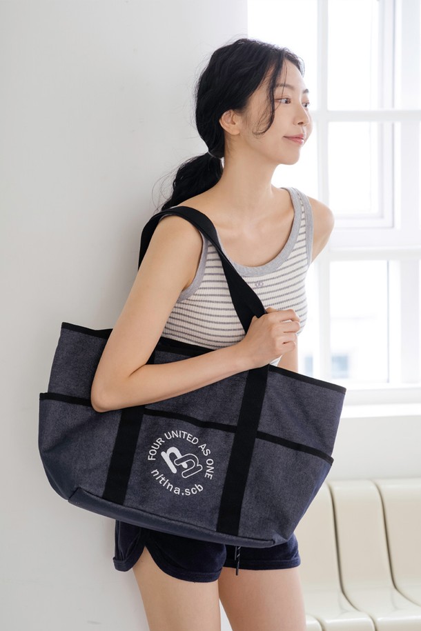 **데님 숄더 백 BL**

블루와 블랙 컬러로 만나볼 수 있는 데님 숄더 백입니다. 넉넉한 라지 사이즈로, 면과 폴리에스테르 혼방 소재로 제작되어 튼튼합니다. 가방 전면에 자수 로고 장식이 돋보이며, 내부에는 7개의 포켓이 있어 수납력을 높였습니다. 스냅 잠금 방식으로 편리하며, 긴 손잡이로 어깨에 편안하게 멜 수 있습니다. 캐주얼, 클래식, 미니멀한 스타일을 즐기는 분들께 데일리, 여행, 골프룩에 활용하기 좋은 아이템입니다.
