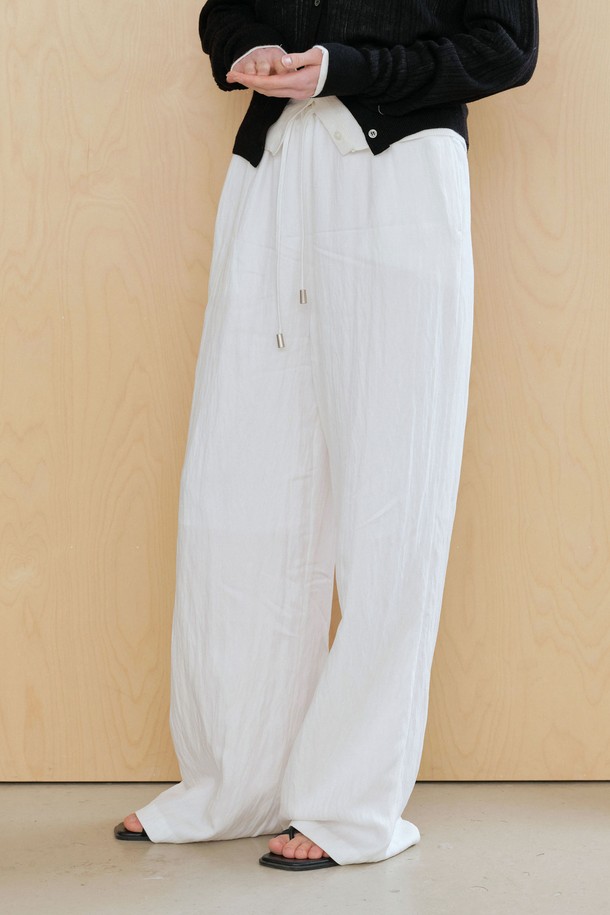 **링클 스트링 팬츠 (2컬러)**

부드러운 촉감의 링클 소재로 제작된 여성 링클 스트링 팬츠입니다. 와이드 핏과 릴랙스 핏으로 편안한 착용감을 선사하며, 허리에는 스트링 끈이 있어 사이즈 조절이 용이합니다. 봄, 여름, 가을 시즌에 활용하기 좋으며, 베이직, 캐주얼 스타일 연출에 적합합니다. 화이트와 블랙 두 가지 컬러로 출시되었으며, 화이트 컬러에는 안감이 있어 비침 걱정을 덜었습니다. 일상, 카페, 여행 등 다양한 TPO에 매치하기 좋은 아이템입니다.
