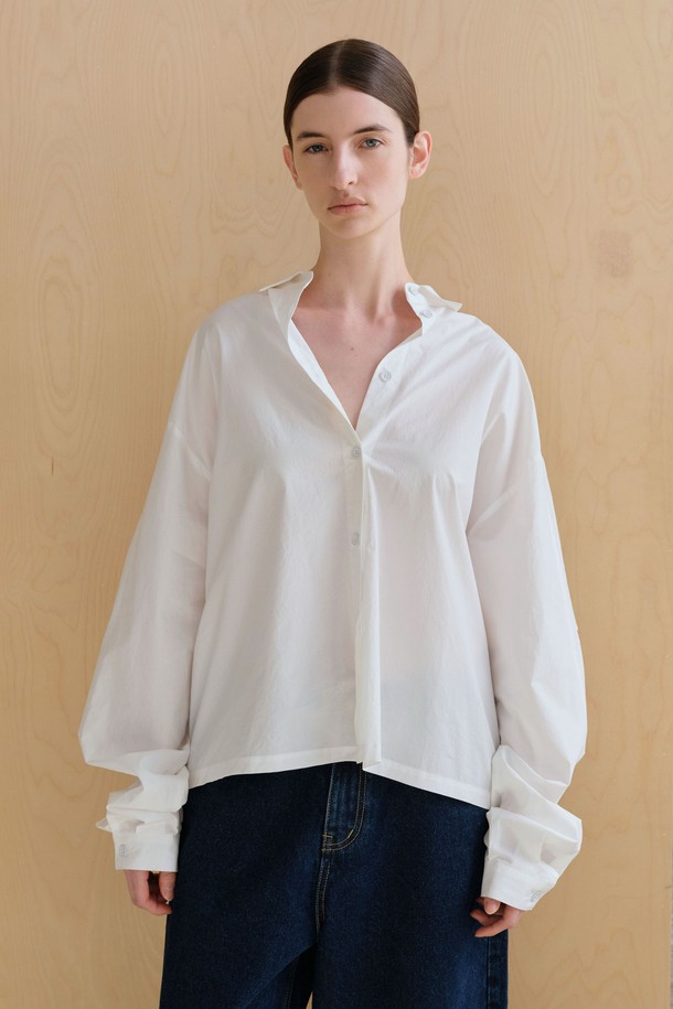 **스트링 볼륨 셔츠**

미니멀하고 베이직한 스타일의 여성용 셔츠/블라우스입니다. 아이보리 컬러의 얇은 면 소재로 제작되었으며, 봄 시즌에 적합합니다. 브이넥 디자인과 루즈핏, 오버핏의 편안한 착용감을 선사하며, 볼륨감 있는 구조적 디자인과 플리츠 디테일이 특징입니다. 뒷면 스트링 디테일로 포인트를 더했고, 60수 고밀도 바이오 원단을 사용하여 부드러운 촉감을 느낄 수 있습니다. 데이트룩, 카페룩, 미니멀, 클래식, 캐주얼 스타일을 연출하기 좋습니다.
