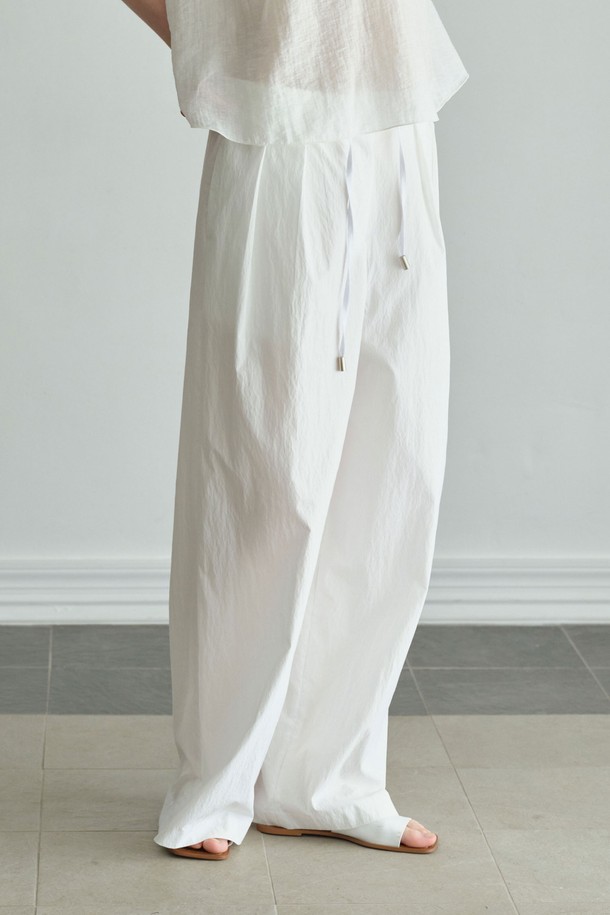 미니멀하고 베이직한 스타일의 '크리스피 밴딩 팬츠'는 편안한 착용감과 세련된 디자인을 동시에 갖춘 여성 밴딩 팬츠입니다. 부드럽고 가벼운 면과 나일론 혼방 소재로 제작되어 사계절 내내 활용 가능하며, 와이드 핏과 루즈핏으로 편안함을 더했습니다. 허리 밴딩과 스트링으로 허리 라인을 잡아주며, 투 플리츠 디테일이 특징입니다. 블랙, 화이트 두 가지 컬러로 출시되어 데일리룩, 동네 마실룩, 카페룩 등 다양한 TPO에 맞춰 스타일링할 수 있으며, 세트 스타일링도 가능합니다.
