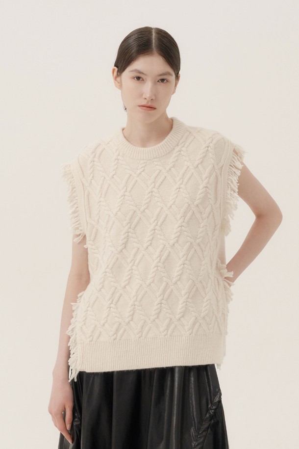 아이보리 컬러의 프린지 울 니트 베스트입니다. 부드러운 촉감의 울 소재로 제작되어 가을, 겨울철 따뜻하게 착용할 수 있습니다. 라운드넥 디자인에 레귤러핏으로 제작되었으며, 케이블 패턴이 돋보이는 캐주얼하고 베이직한 스타일의 상의입니다. 민소매 기장으로 다양한 상의와 레이어드하여 모임룩이나 일상룩에 활용하기 좋습니다. 프린지 디테일이 포인트로 더해져 유니크한 매력을 선사합니다.
