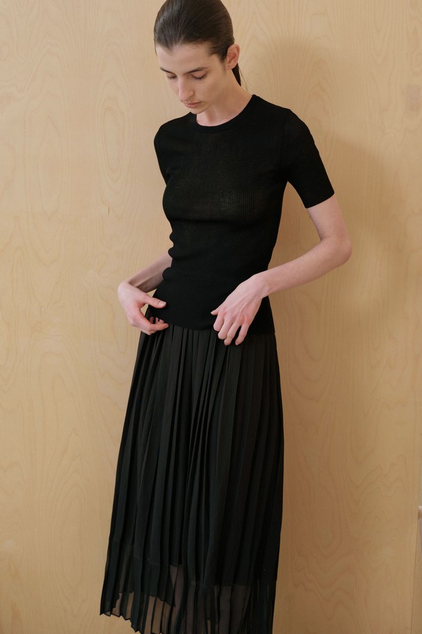 세련된 블랙 컬러의 플리츠 스커트입니다. 레이온, 나일론, 폴리에스테르 혼방 소재로 제작되어 부드러운 촉감을 선사합니다. 얇은 두께감과 언밸런스 플리츠 디자인, 밑단 시스루 디테일이 우아하면서도 시크한 무드를 연출합니다. 레귤러 핏의 맥시스커트로, 데이트룩, 모임룩, 카페룩 등 다양한 TPO에 활용하기 좋습니다. 안감은 없으며, 신축성은 없습니다.
