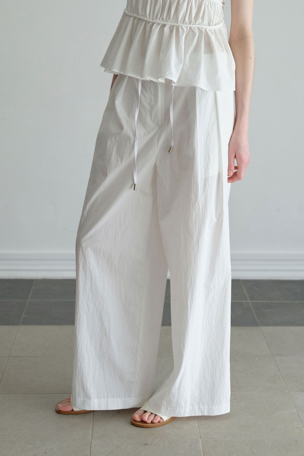 미니멀하고 베이직한 스타일의 '크리스피 밴딩 팬츠'는 편안한 착용감과 세련된 디자인을 동시에 갖춘 여성 밴딩 팬츠입니다. 부드럽고 가벼운 면과 나일론 혼방 소재로 제작되어 사계절 내내 활용 가능하며, 와이드 핏과 루즈핏으로 편안함을 더했습니다. 허리 밴딩과 스트링으로 허리 라인을 잡아주며, 투 플리츠 디테일이 특징입니다. 블랙, 화이트 두 가지 컬러로 출시되어 데일리룩, 동네 마실룩, 카페룩 등 다양한 TPO에 맞춰 스타일링할 수 있으며, 세트 스타일링도 가능합니다.
