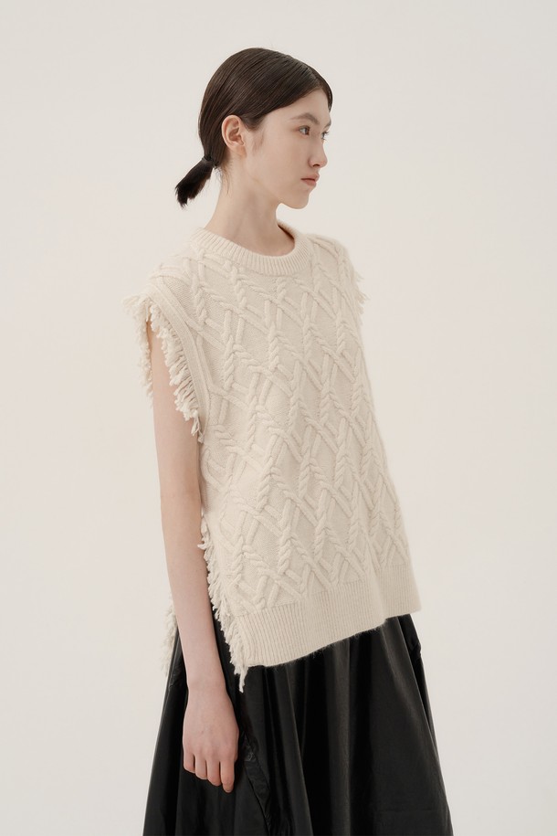 아이보리 컬러의 프린지 울 니트 베스트입니다. 부드러운 촉감의 울 소재로 제작되어 가을, 겨울철 따뜻하게 착용할 수 있습니다. 라운드넥 디자인에 레귤러핏으로 제작되었으며, 케이블 패턴이 돋보이는 캐주얼하고 베이직한 스타일의 상의입니다. 민소매 기장으로 다양한 상의와 레이어드하여 모임룩이나 일상룩에 활용하기 좋습니다. 프린지 디테일이 포인트로 더해져 유니크한 매력을 선사합니다.
