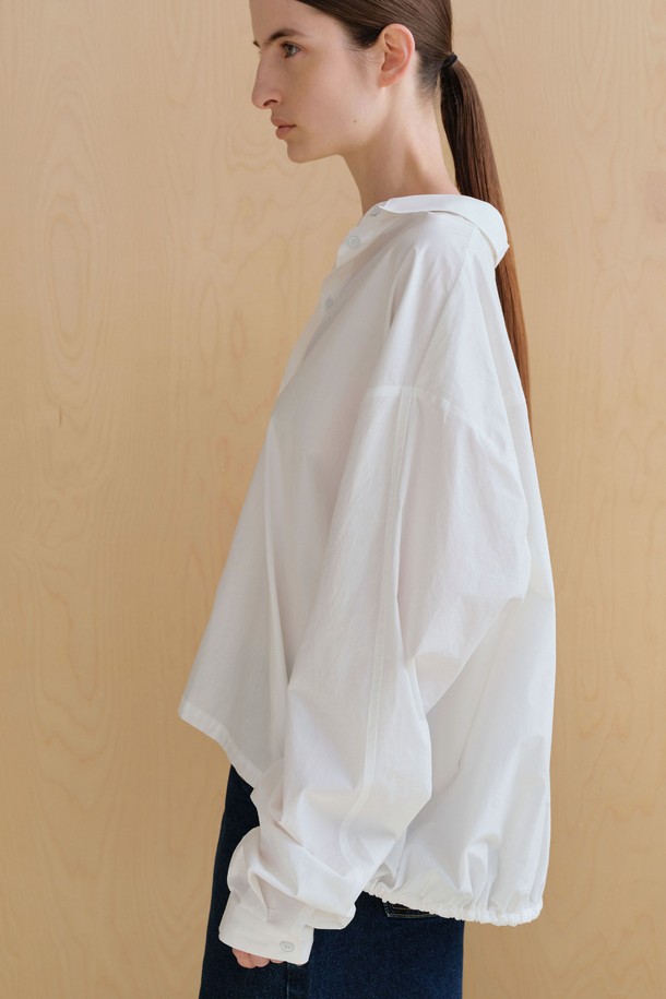 **스트링 볼륨 셔츠**

미니멀하고 베이직한 스타일의 여성용 셔츠/블라우스입니다. 아이보리 컬러의 얇은 면 소재로 제작되었으며, 봄 시즌에 적합합니다. 브이넥 디자인과 루즈핏, 오버핏의 편안한 착용감을 선사하며, 볼륨감 있는 구조적 디자인과 플리츠 디테일이 특징입니다. 뒷면 스트링 디테일로 포인트를 더했고, 60수 고밀도 바이오 원단을 사용하여 부드러운 촉감을 느낄 수 있습니다. 데이트룩, 카페룩, 미니멀, 클래식, 캐주얼 스타일을 연출하기 좋습니다.
