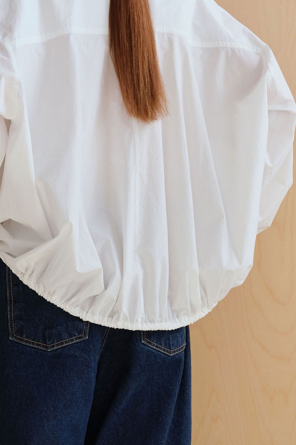 **스트링 볼륨 셔츠**

미니멀하고 베이직한 스타일의 여성용 셔츠/블라우스입니다. 아이보리 컬러의 얇은 면 소재로 제작되었으며, 봄 시즌에 적합합니다. 브이넥 디자인과 루즈핏, 오버핏의 편안한 착용감을 선사하며, 볼륨감 있는 구조적 디자인과 플리츠 디테일이 특징입니다. 뒷면 스트링 디테일로 포인트를 더했고, 60수 고밀도 바이오 원단을 사용하여 부드러운 촉감을 느낄 수 있습니다. 데이트룩, 카페룩, 미니멀, 클래식, 캐주얼 스타일을 연출하기 좋습니다.
