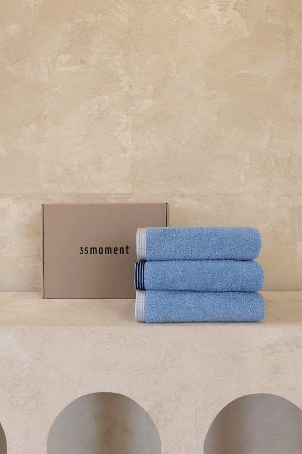 [선물포장] 페이스 타월 3P_코지 블루는 부드러운 촉감과 뛰어난 흡습/속건 기능을 갖춘 40cm x 90cm 사이즈의 페이스 타월 3P 세트입니다. 고밀도 직조의 면 & 폴리에스테르 혼방 40수 코마사 원단으로 제작되었으며, 시원한 코지 블루 컬러와 스트라이프 패턴으로 디자인되었습니다. OEKO-TEX STANDARD 100 인증 및 형광증백제 무첨가로 민감성 피부에도 안심하고 사용할 수 있으며, 선물 포장과 메시지 카드가 함께 제공되어 소중한 분들께 선물하기 좋습니다.
