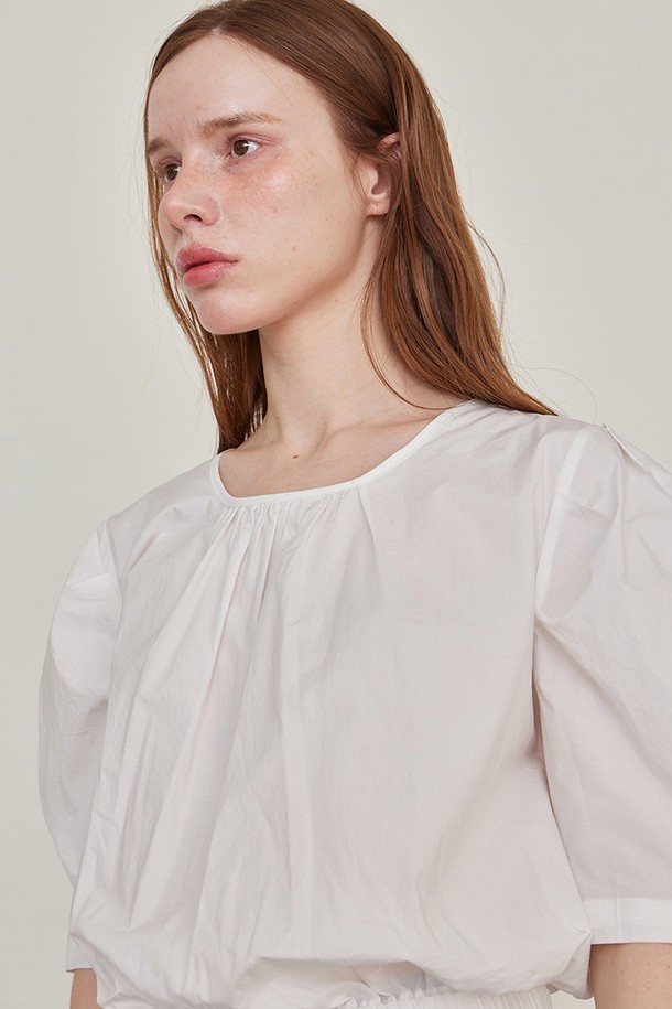 레브 셔링 하프 블라우스 - 화이트는 페미닌한 무드의 여성 블라우스입니다. 라운드넥 디자인에 네크라인 셔링 디테일과 목 뒤 스트랩으로 포인트를 주었습니다. 얇은 두께의 면 소재로 제작되어 여름에도 시원하게 착용 가능하며, 루즈핏으로 편안한 착용감을 선사합니다. 허리 밴딩과 볼륨감 있는 소매가 특징이며, 데이트룩 및 모임룩, 로맨틱 및 미니멀 스타일 연출에 적합합니다.
