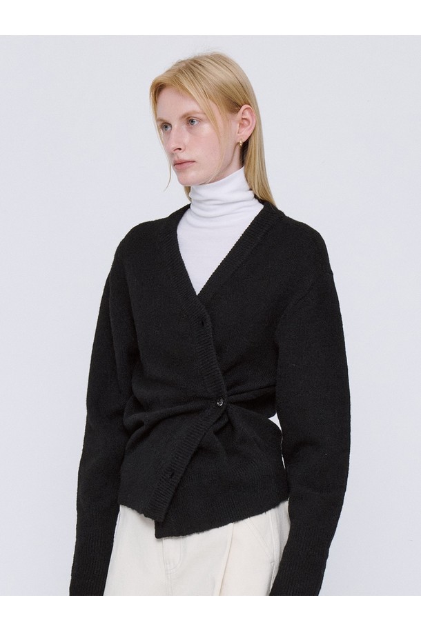 부드러운 울 소재의 블랙 Soft Wool Knit Wrap 카디건입니다. 가을과 겨울에 어울리는 두꺼운 두께감으로 따뜻함을 선사하며, 레귤러 핏과 브이넥 디자인으로 여성스러운 실루엣을 연출합니다. 랩 스타일의 싱글 버튼 여밈으로 세련된 포인트를 더했으며, 긴 소매 기장으로 더욱 포근한 느낌을 줍니다. 베이직, 미니멀, 시크 스타일을 즐기는 여성분들을 위한 출근룩, 모임룩, 데이트룩에 적합한 아이템입니다.
