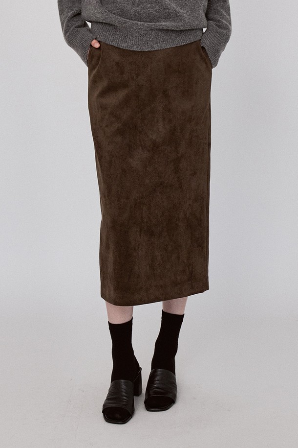 **베이직 스웨이드 롱 스커트 - 카키브라운**

부드러운 촉감의 베이직 스웨이드 롱 스커트입니다. 슬림핏 H라인으로 떨어지는 미디엄 기장의 스커트로, 가을 시즌 데이트룩과 모임룩에 적합합니다. 카키 브라운과 블랙 두 가지 색상으로 출시되었으며, 미니멀하고 시크한 스타일을 연출하기 좋습니다. 허리 양쪽 대각선 포켓과 백 슬릿 디테일이 돋보이며, 백 센터 지퍼와 버튼으로 간편하게 여밀 수 있습니다. 폴리에스테르와 폴리우레탄 혼방 소재로 제작되어 편안하게 착용 가능합니다.
