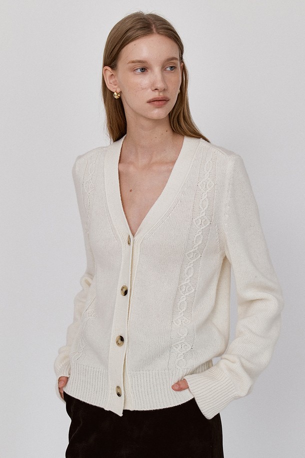 **코지 케이블 니트 가디건 - 아이보리**

부드러운 촉감의 아이보리 컬러 '코지 케이블 니트 가디건'입니다. 여성용 니트/스웨터 카테고리에 속하며, 가을과 겨울에 따뜻하게 입을 수 있습니다. 릴랙스핏으로 편안하게 착용 가능하며, 브이넥 디자인과 긴 소매 기장이 특징입니다. 케이블 및 골지 패턴, 두꺼운 두께감으로 보온성을 높였으며, 리브드 소매단과 밑단, 프론트 테이블 스티치 디자인으로 포인트를 더했습니다. 겨울 데일리룩, 카페룩, 캐주얼, 클래식, 미니멀 스타일을 연출하기에 좋습니다.
