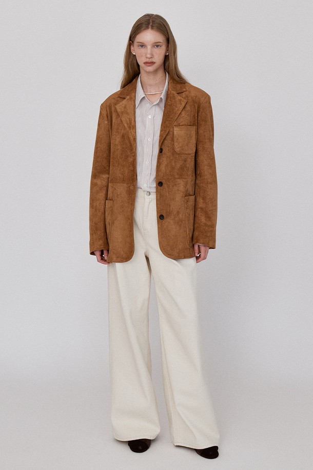 부드러운 스웨이드 소재의 브라운 블레이저 재킷입니다. 미니멀하고 클래식한 디자인으로, 오피스룩, 비즈니스 캐주얼, 모임룩 등 다양한 TPO에 활용하기 좋습니다. 가을 시즌에 적합하며, 얇은 두께감과 오버핏으로 편안한 착용감을 선사합니다. 숄더 패드 디테일과 브랜드 로고가 각인된 버튼, 절개 디테일이 돋보이며, 긴 소매와 싱글 버튼 여밈으로 시크한 스타일을 연출합니다.
