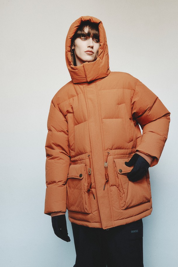 BRITISH CAMPER (브리티시 캠퍼) 미디 다운 점퍼 - 오렌지 (P254MDW452)는 추운 겨울 날씨에도 따뜻하고 스타일리시하게 연출할 수 있는 여성용 다운 점퍼입니다. 캐주얼, 미니멀, 고프코어 스타일을 아우르는 디자인으로, 산책룩이나 캠핑룩에 잘 어울립니다. 오버핏, 두꺼운 두께감, 부드러운 촉감의 나일론 소재를 사용하여 편안한 착용감을 제공하며, 하이넥과 퍼프 소매, 포켓 디테일이 돋보입니다. 숏패딩 스타일의 미디 기장으로, 보온성과 방풍 기능을 갖춰 겨울철 따뜻함을 유지해 줍니다. 
