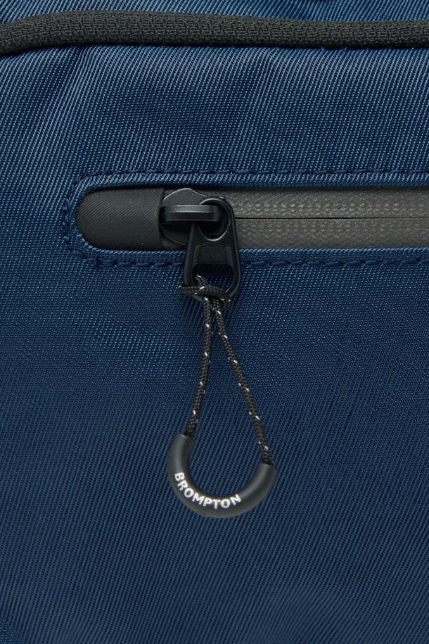 **REFLECTIVE CROSS BAG - D/NAVY (P255ACR103)**

미니멀한 'REFLECTIVE CROSS BAG' (리플렉티브 크로스 백) - D/NAVY는 남성 고객을 위한 가방입니다. 네이비와 블랙 컬러로 출시되었으며, 일상, 출퇴근, 사이클 용도로 적합합니다. 사각 형태에 지퍼형 잠금방식이며, 리플렉티브 지퍼, 프린트 라벨, 버클 스트랩 디테일이 돋보입니다. 재귀반사 기능과 내마모성이 뛰어나며, 경량의 리사이클 나일론과 폴리에스터 소재를 사용하여 봄, 여름, 가을, 겨울 사계절 모두 착용 가능합니다. 군더더기 없는 실루엣과 절제된 디테일이 '시티보이' 스타일과 '출근룩'에 완벽하게 어울립니다.
