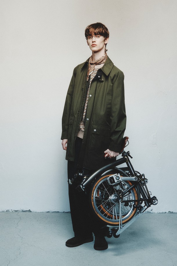 올리브 컬러의 남성용 벤타일 코트입니다. 가을, 겨울 시즌에 적합하며, 클래식하고 밀리터리 스타일을 연출할 수 있습니다. 뻣뻣한 촉감의 두꺼운 벤타일 소재로 제작되었으며, 레귤러핏과 레귤러 기장으로 편안하게 착용 가능합니다. 플랩 포켓, 칼라 디자인, 버튼 커프스가 특징이며, 버튼 여밈 방식으로 디자인되었습니다. 출근룩, 비즈니스 캐주얼, 모임룩 등 다양한 TPO에 활용 가능하며, 클래식, 미니멀, 워크웨어 스타일을 즐기는 분들께 추천합니다.
