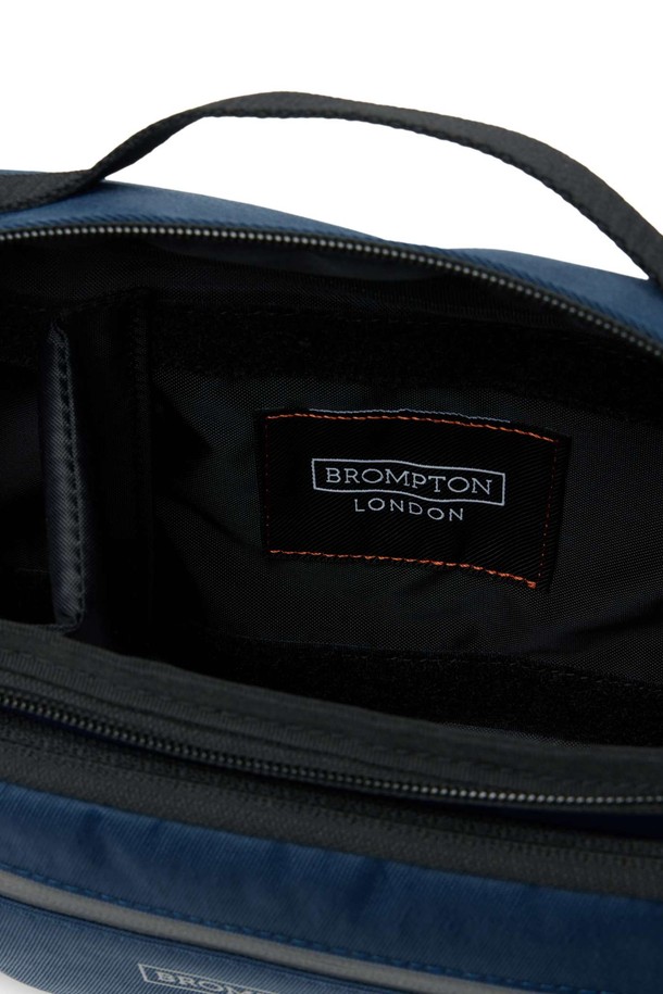 **REFLECTIVE CROSS BAG - D/NAVY (P255ACR103)**

미니멀한 'REFLECTIVE CROSS BAG' (리플렉티브 크로스 백) - D/NAVY는 남성 고객을 위한 가방입니다. 네이비와 블랙 컬러로 출시되었으며, 일상, 출퇴근, 사이클 용도로 적합합니다. 사각 형태에 지퍼형 잠금방식이며, 리플렉티브 지퍼, 프린트 라벨, 버클 스트랩 디테일이 돋보입니다. 재귀반사 기능과 내마모성이 뛰어나며, 경량의 리사이클 나일론과 폴리에스터 소재를 사용하여 봄, 여름, 가을, 겨울 사계절 모두 착용 가능합니다. 군더더기 없는 실루엣과 절제된 디테일이 '시티보이' 스타일과 '출근룩'에 완벽하게 어울립니다.
