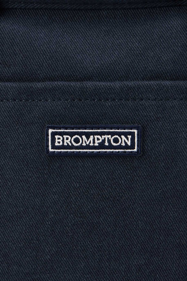 SMALL TOTE BAG (스몰 토트백) - 네이비 컬러의 남성용 토트백입니다. 면 소재로 제작되었으며, 스몰 사이즈의 사각 쉐입에 로고 패턴과 스터드/찡 및 자수 디자인 장식이 돋보입니다. 2WAY 기능과 손잡이로 다양한 연출이 가능하며, 넓은 개구부와 자연스러운 워싱 텍스처가 특징입니다. 오픈형 잠금 방식으로 편리하며, 크로스백으로도 활용 가능하여 동네 마실룩, 쇼핑룩 등 캐주얼, 미니멀, 시티보이 스타일을 연출하기 좋습니다.
